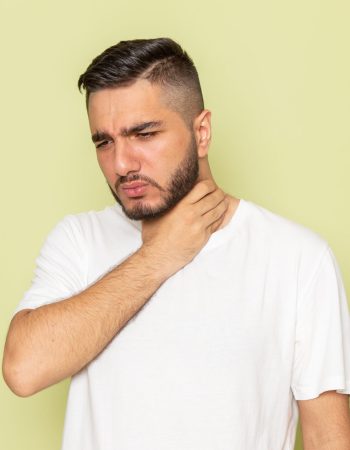 A man holding his throat full of deep throat tonsil stones